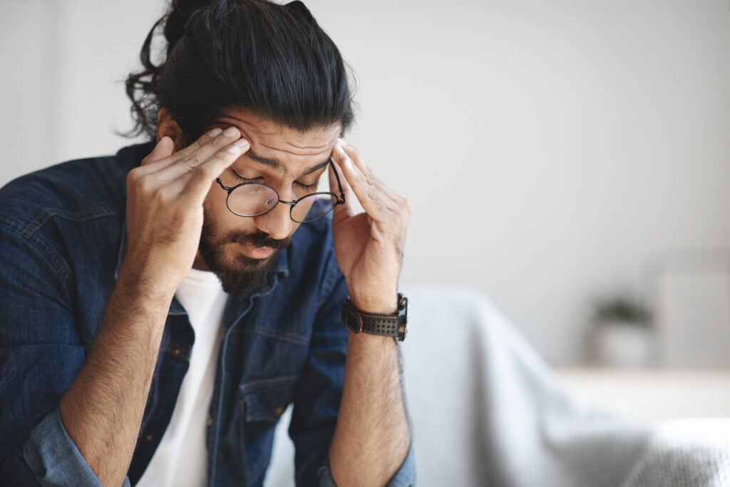 Mann macht sich Gedanken wegen der Migräne dauer  