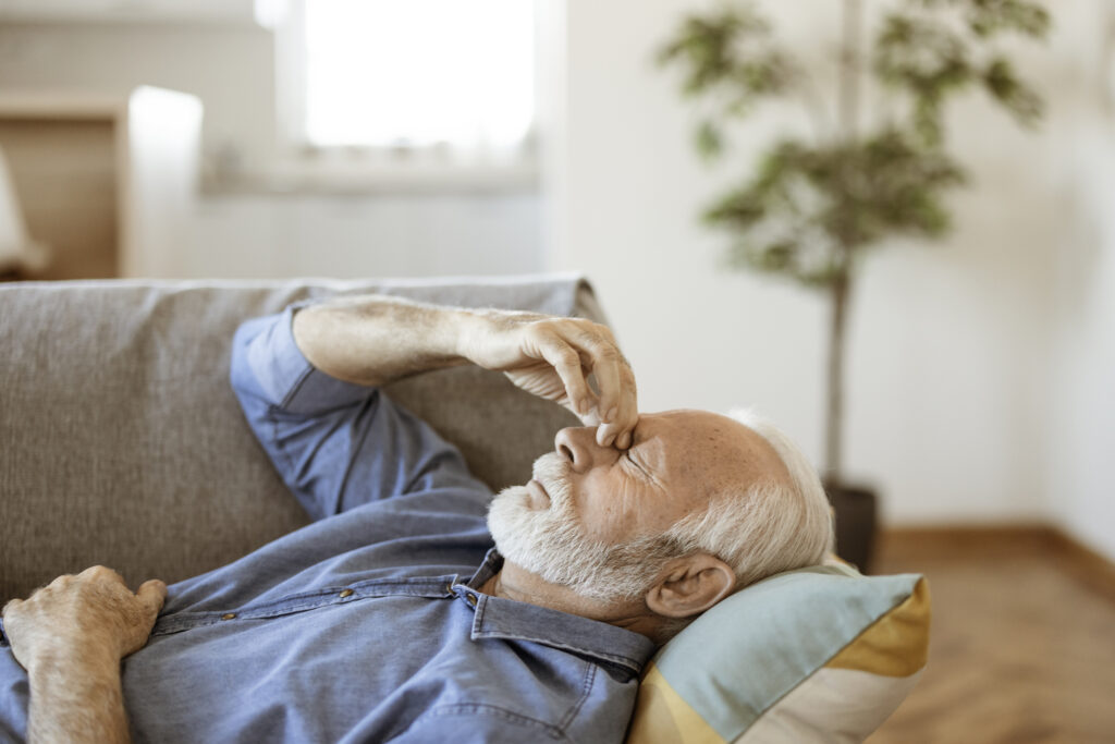 Alter Mann beim behandeln von Migräne
