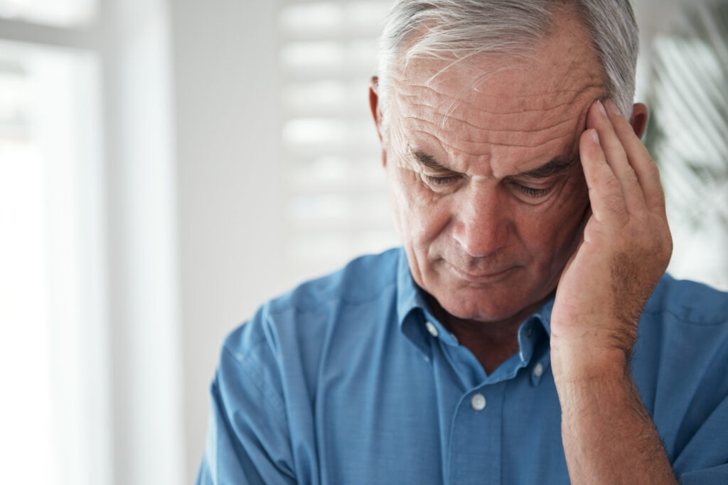 Alter Mann mit denn Ursachen von Kopfschmerzen 